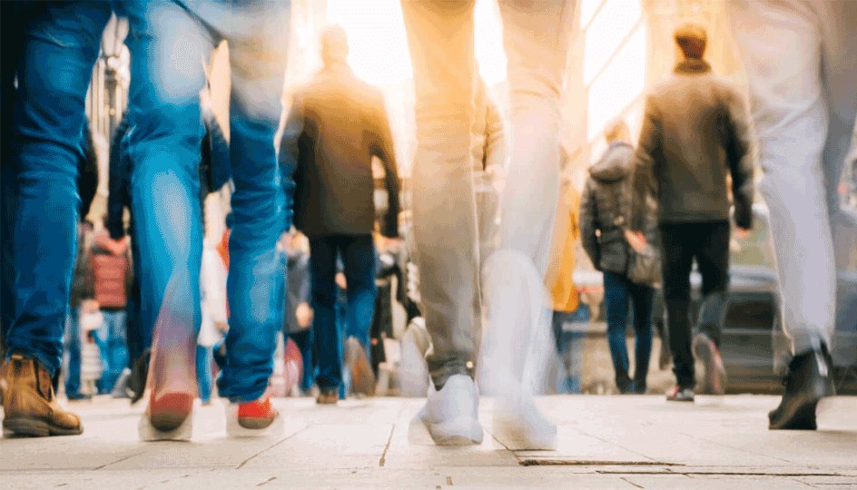 Crowd of people walking in motion in downtown rush hour