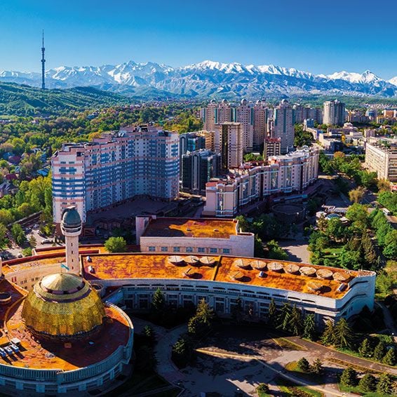 A scenic view of Almaty Kazakhstan highlighting the city's diverse architecture and the surrounding mountains